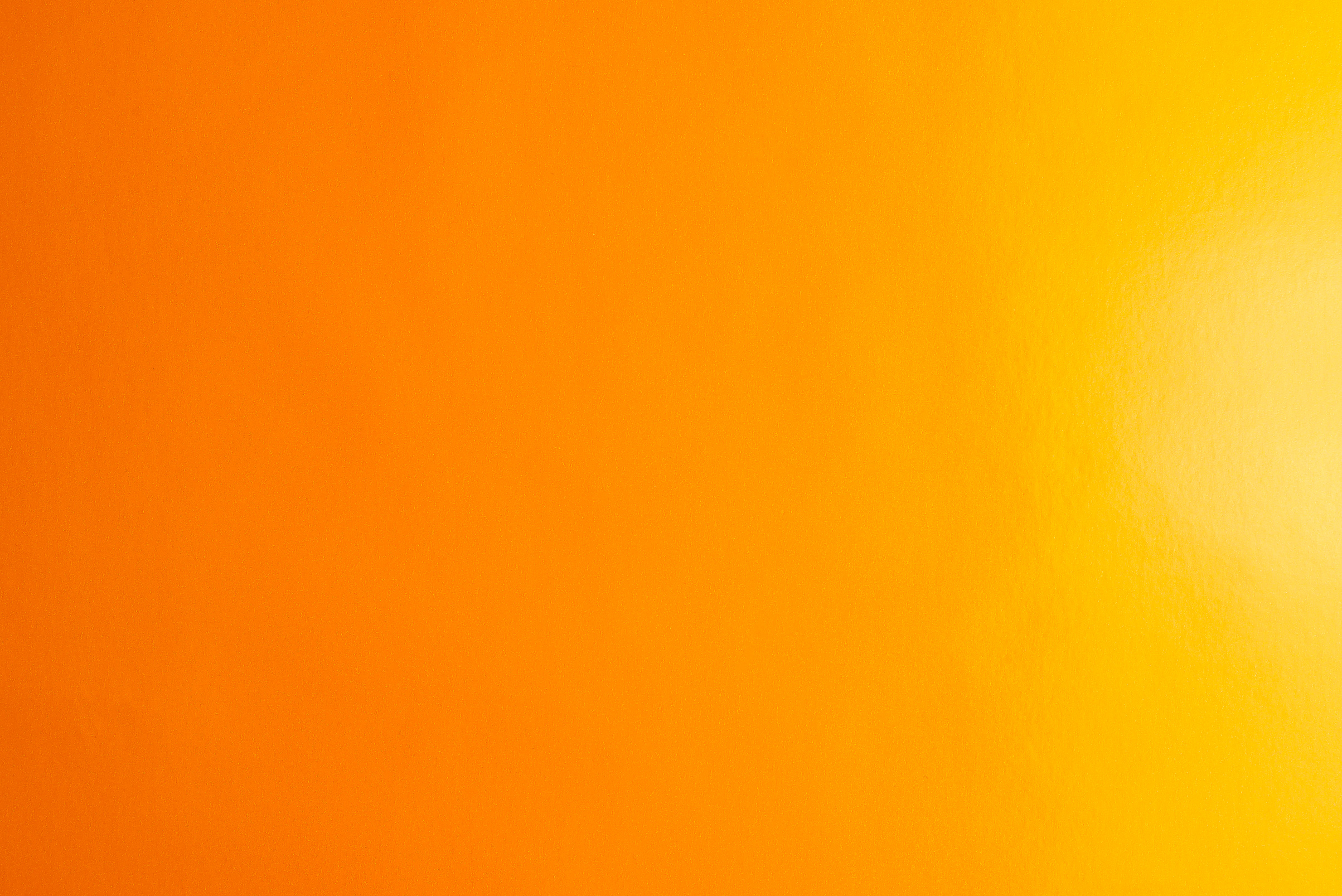 Orange background made of real colored paper, illuminated by a soft light from the right.